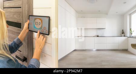 Woman using smart wall home control system Stock Photo
