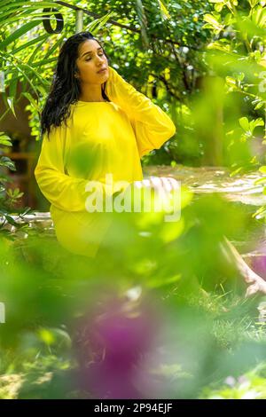 North America, Caribbean, Greater Antilles, Hispaniola Island, Dominican Republic, Sama, Las Galeras, Attractive woman sitting in tropical garden of boutique hotel Chalet Tropical Stock Photo