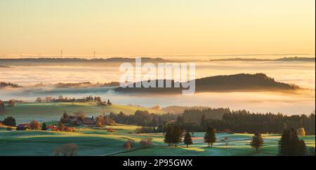 Atmospheric sunrise in the Allgäu. View over the misty Illertal valley to the wind turbines of Wildpoldsried. Bavaria, Germany Stock Photo