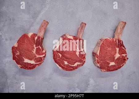 Overhead Shot Of Tomahawk Beef Steaks On Background In Butcher's Shop Display Stock Photo