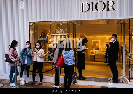 Hong Kong, China. 10th Mar, 2023. Shoppers queue in line to enter a luxury fashion brand Dior store in Tsim Sha Tsui shopping district. (Credit Image: © Keith Tsuji/ZUMA Press Wire) EDITORIAL USAGE ONLY! Not for Commercial USAGE! Stock Photo