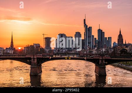 View from the Flöserbrücke bridge in Frankfurt am main, Hesse, Germany, over the river Main to the skyline, the banking district and the city center. Sunset with evening red Stock Photo