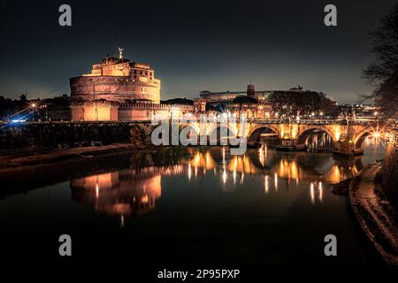 The Bridge of Angels/ Pons Aelius / Ponte Sant'Angelo overlooking the Castel Sant'Angelo Cortile d'onore o cortile dell'Angelo at night, illuminated. Rome, Italy Stock Photo