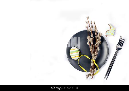 Decorative eggs and  brunch willow on black plate on white background. Happy Easter minimal concept. Flat lay trendy easter. Happy easter card. Copy s Stock Photo
