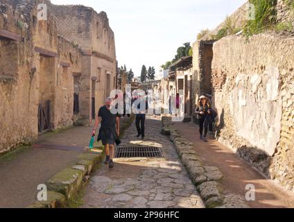 Herculaneum uncovered. Herculaneum was buried under volcanic ash and pumice in the eruption of Mount Vesuvius in AD 79. Ercolano, Campania, Italy . Street with tourists visiting Stock Photo