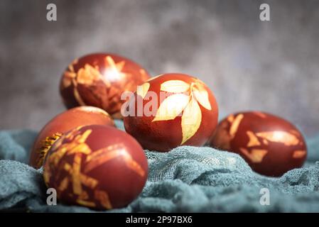 Dyed Easter eggs painted with natural dye onion on gray background. Natural ecological staining with food coloring. Top view. Stock Photo