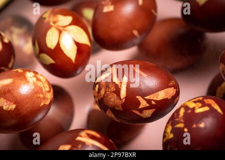 Dyed Easter eggs painted with natural dye onion on gray background. Natural ecological staining with food coloring. Top view. Stock Photo