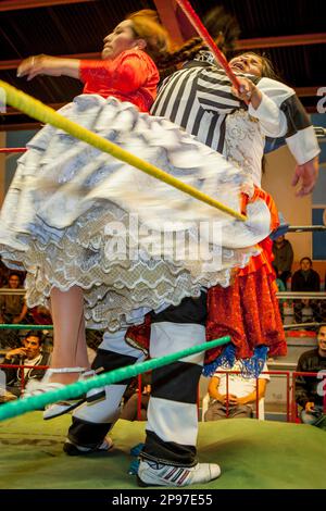 Lucha Libre. Combat between Dina with orange skirt and Benita la Intocable , cholitas females wrestlers ,with referee in the middle, Sports center La Stock Photo