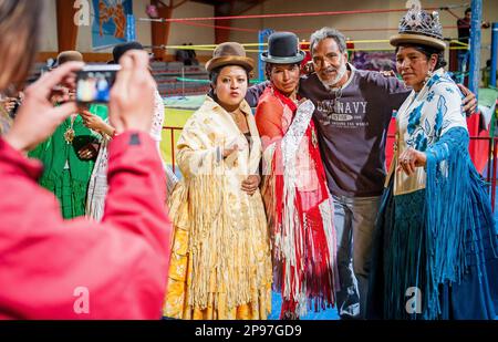 Lucha Libre. After the show. A follower is photographed with cholitas fighters. At left Julieta, in the middle Celia la Simpatica, and Dina , cholitas Stock Photo