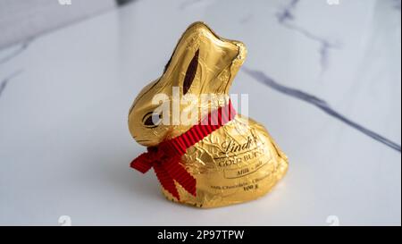 Surrey, Canada- March 10 2023:A Lindt Gold Bunny milk chocolate treat wrapped in gold foil with a signature red ribbon and bell. Stock Photo