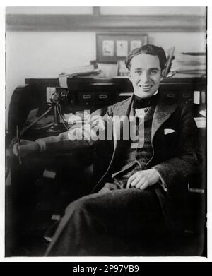 1915 ca : The celebrated english actor and movie director CHARLES CHAPLIN ( 1889 - 1977 ) - CINEMA MUTO   SILET MOVIE  - portrait - ritratto  - regista cinematografico - attore -  comico - desk - scrittoio - scrivania - phone - telephone - telefono - ufficio - office - smile - sorriso  ----   Archivio GBB Stock Photo