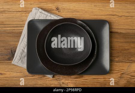 Empty Black Bowls and Plates on Wooden Table Background, Black Plate Mockup Top View, Rustic Kitchen Mock Up with Copy Space Stock Photo