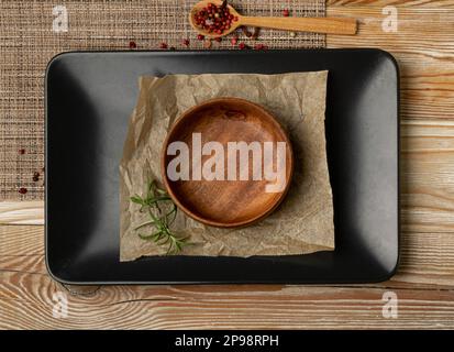 Empty Black Bowls and Wood Plates on Wooden Table Background, Black Plate Mockup Top View, Rustic Kitchen Mock Up with Copy Space Stock Photo