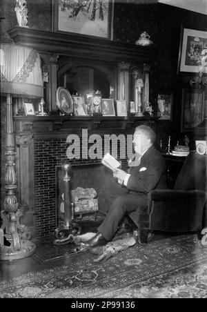 1914 , New York , USA : The irish-born american music composer  VICTOR HERBERT ( 1859 - 1924 )  at home . Herbert , also a noted cellist and conductor , was an enormously successful composer of operettas such an as BABES IN TOYLAND , MLLE MODISTE . THE RED MILL and NAUGHTY MARIETTA . He also composed many instrumental pieces and grand operas ( inclunding NATOMA )  without achieving the success of his lighter music .     - COMPOSITORE - OPERA LIRICA - OPERETTA - CLASSICA - CLASSICAL - PORTRAIT - RITRATTO - MUSICISTA - MUSICA  -  baffi - moustache -  book - libro - lettore - reader - caminetto Stock Photo