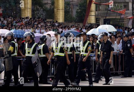 FILE--A Chinese police officer and workers confiscate fake Louis