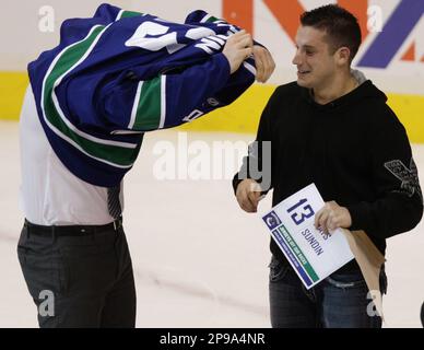 Actor John Travolta holds a Vancouver Canucks jersey during the NHL News  Photo - Getty Images
