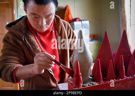 Monk making offerings, in Gaden Shartse monastery.McLeod Ganj, Dharamsala, Himachal Pradesh state, India, Asia Stock Photo