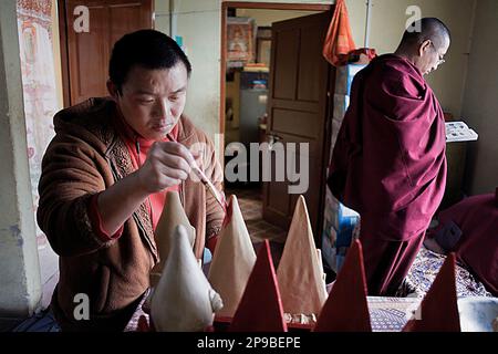 Monk making offerings, in Gaden Shartse monastery.McLeod Ganj, Dharamsala, Himachal Pradesh state, India, Asia Stock Photo