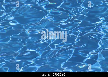 Sunlight and reflections dancing on the rippled surface of the open air Riviera swimming pool aboard the cruise ship Aurora, April 2022. Stock Photo