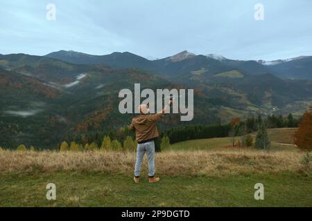 Young man with modern drone in mountains, back view Stock Photo