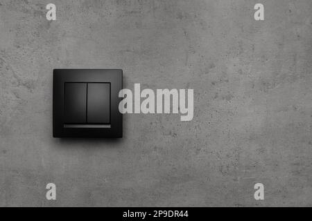 Black light switch on grey background. Space for text Stock Photo