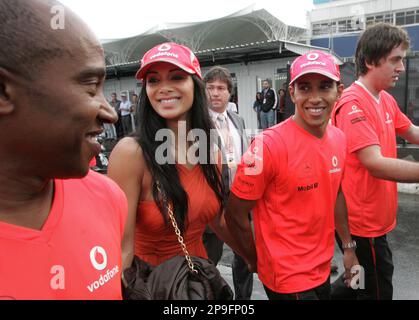 McLaren-Mercedes' driver Lewis Hamilton, of Britain, looks at his father Anthony, left, as he leaves the Interlagos race track with his girlfriend Nicole Scherzinger after winning the Formula One drivers world championship title at the Brazilian Grand Prix on Interlagos race track in Sao Paulo, Sunday, Nov. 2, 2008. (AP Photo/Andre Penner)