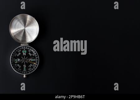 photo of a compass on isolated black background, after some edits. Stock Photo