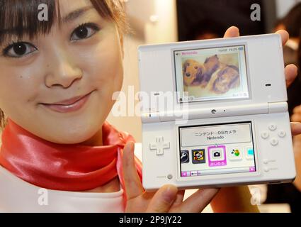 A model shows a Nintendo DSi, the revamped version of Nintendo's