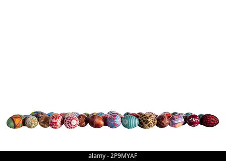 Different colors and patterns of Easter eggs lined up in a row on a white background. Stock Photo