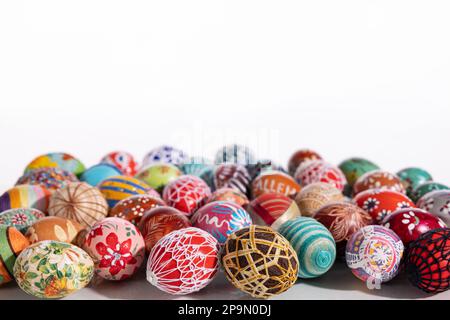 Lots of colorful Easter eggs laid out randomly on a solid white background. Stock Photo
