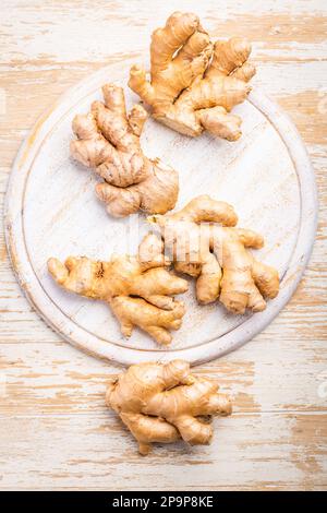 Ginger roots on white wooden background. Stock Photo