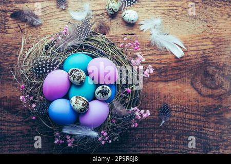 Happy Easter - nest with Easter eggs on wooden background with copy space Stock Photo