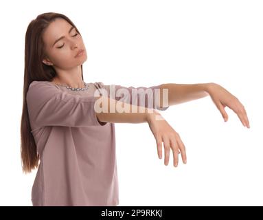 Young woman wearing pajamas in sleepwalking state on white background Stock Photo