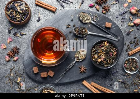 Flat lay composition with freshly brewed tea and dry leaves on grey table Stock Photo