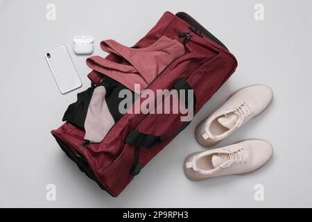 Gym bag and sports equipment on light grey background, flat lay Stock Photo