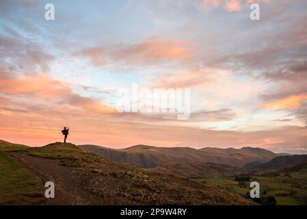 Wonderful sunset landscape image of view from Latrigg Fell towards Great Dodd and Stybarrow Dodd in Lake District with man photographing the landscape Stock Photo