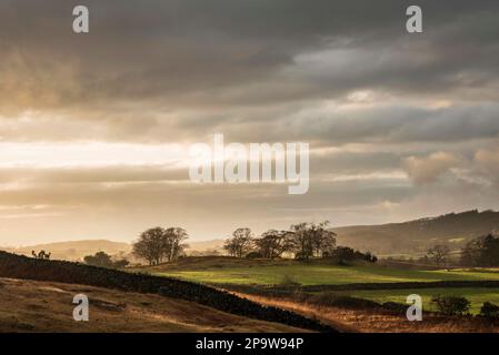 Stunning Winter sunset golden hour landscape image of view from Wast Water over countryside in Lake District towards the Western district Stock Photo