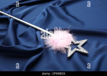 Beautiful silver magic wand with feather on blue fabric Stock Photo