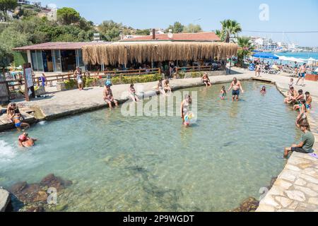 Datca, Mugla, Turkey – August 19, 2022. Ilica-Kargi geothermal bath in Datca resort town of Mugla, Turkey. View of the hot springs with people. Stock Photo