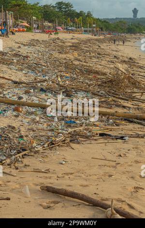 Jimbaran Beach, Indonasia - February 13.2023: Jimbaran beach on Bali with famous fish restaurants full of garbage at the sandy beach Stock Photo