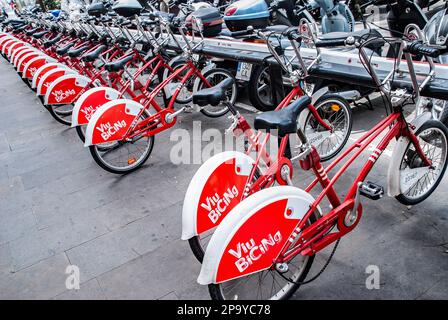 Viu BiCiNg bicycle sharing system in the city of  Barcelona,Spain with red and white bicycles available for hire Stock Photo