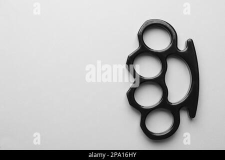 Black brass knuckles on white background, top view. Space for text Stock Photo