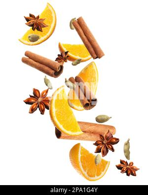 Pieces of fresh orange, aromatic anise stars, cinnamon and cardamom falling on white background Stock Photo