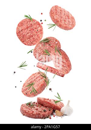 Fresh raw burger patties and seasonings falling on white background Stock Photo