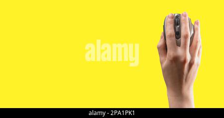 Hand lying on computer mouse, op view. Ad yellow banner, background with copy space for text. Stock Photo