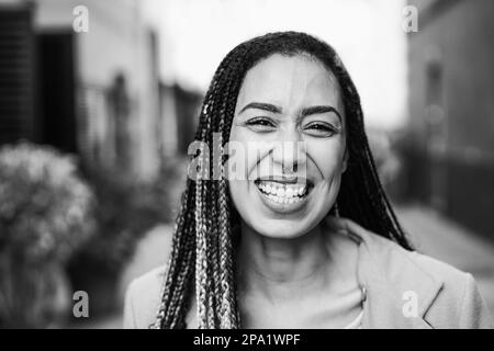 Mixed race girl smiling in front of camera during winter time - Focus on face - Black and white editing Stock Photo