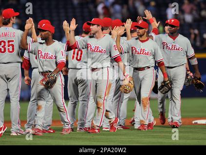 Philadelphia Phillies' Chase Utley (R) and Jimmy Rollins (C) celebrate with  teammate Rail Ibanez after scoring on a Ryan Howard RBI double in the fifth  inning during Game 1 of the National