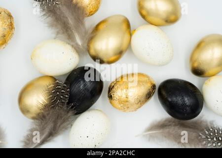 Easter golden and black eggs, feather. Stock Photo