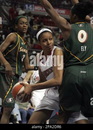 Seattle Storm's Shyra Ely, left, reaches for the ball, but Sacramento