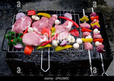 Raw meat skewers with vegetables on wooden background. fresh raw beef shish kebab with pepper chunk on black big grill bbq Stock Photo